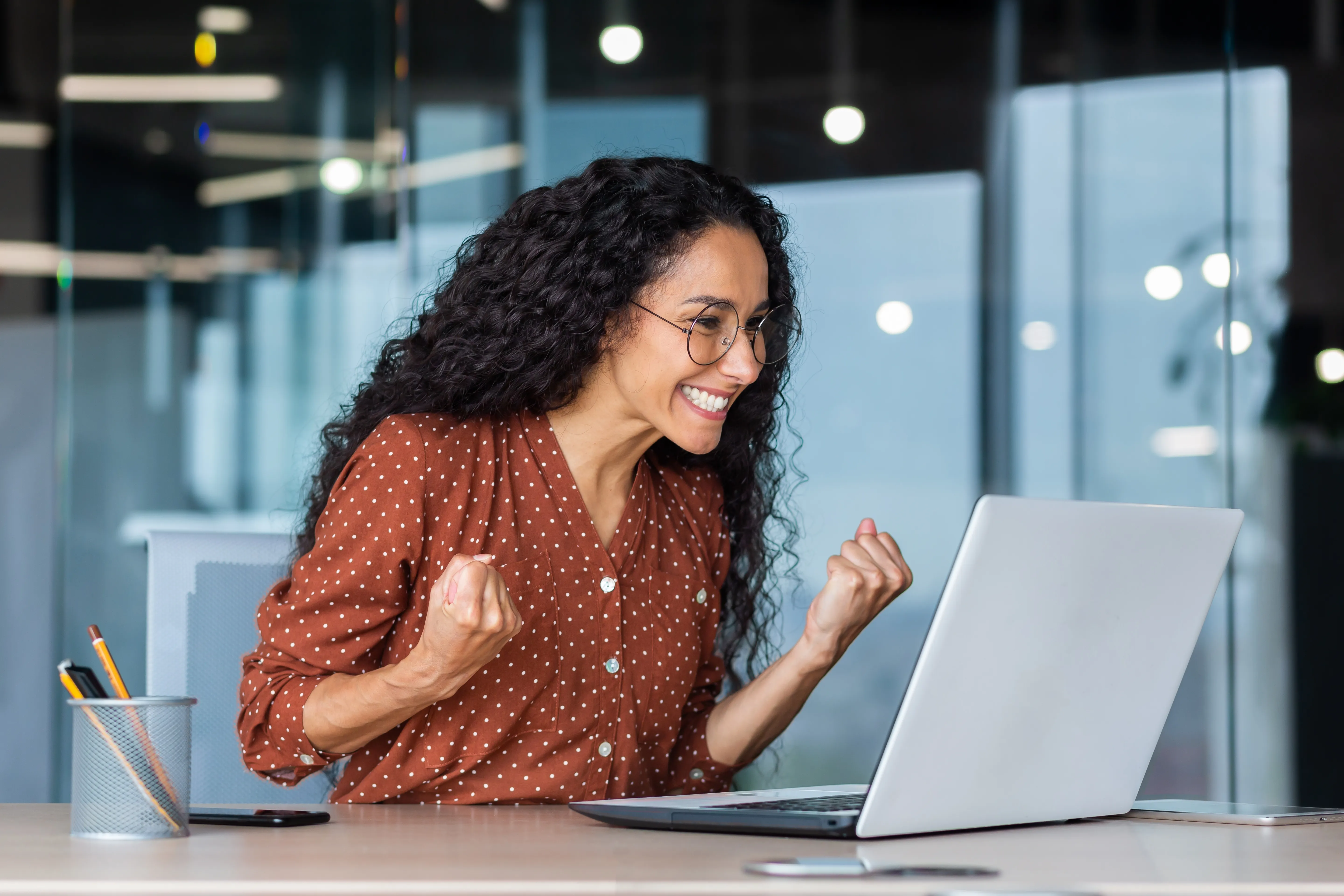 Femme heureuse au bureau célébrant une bonne nouvelle